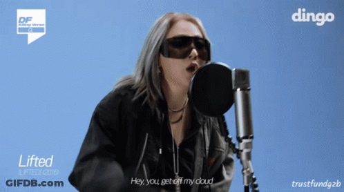 A Woman Singing Into A Microphone With A Dingo Logo On The Bottom GIF