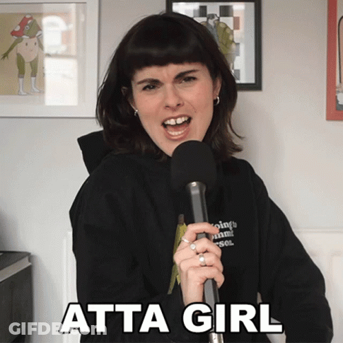 A Woman Singing Into A Microphone With Atta Girl Written On The Bottom Right GIF