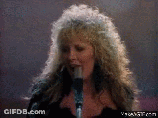 A Woman Singing Into A Microphone With Makeagif.com Written On The Bottom GIF