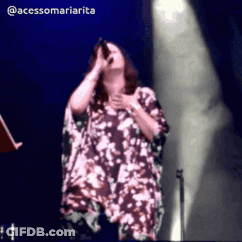 A Woman Singing Into A Microphone With The Hashtag @Acessomariaria GIF