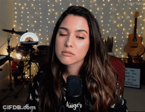 A Woman Singing Into A Microphone With The Name Kuiger On The Bottom GIF