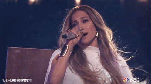A Woman Singing Into A Microphone With The Nbc Logo On The Bottom Right GIF
