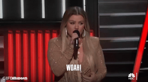 A Woman Singing Into A Microphone With The Word Woah On The Bottom GIF