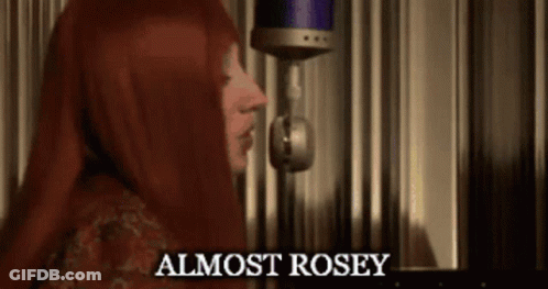 A Woman Singing Into A Microphone With The Words " Almost Rosey " On The Bottom GIF