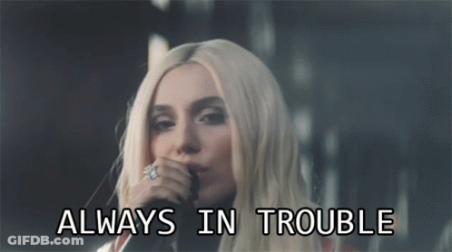 Woman Singing Into Microphone With Always In Trouble Text GIF