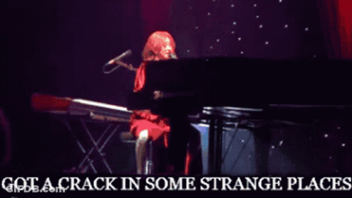 A Woman Singing Into A Microphone With The Words Got A Crack In Some Strange Places Below Her GIF