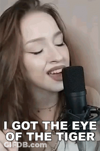 A Woman Singing Into A Microphone With The Words `` I Got The Eye Of The Tiger '' GIF