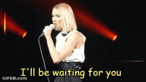 A Woman Singing Into A Microphone With The Words I 'Ll Be Waiting For You Behind Her GIF