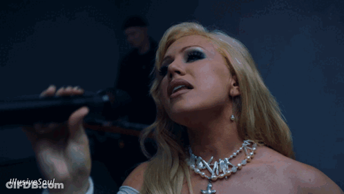 A Woman Singing Into A Microphone With The Words Illusive Soul On The Bottom Right GIF