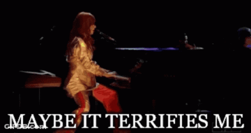 A Woman Singing Into A Microphone With The Words " Maybe It Terrifies Me " Below Her GIF