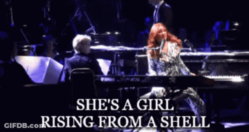 A Woman Singing Into A Microphone With The Words She 'S A Girl Rising From A Shell On The Bottom GIF