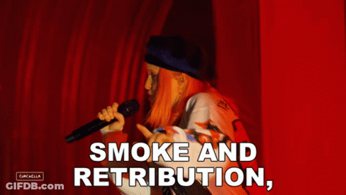A Woman Singing Into A Microphone With The Words " Smoke And Retribution " Above Her GIF