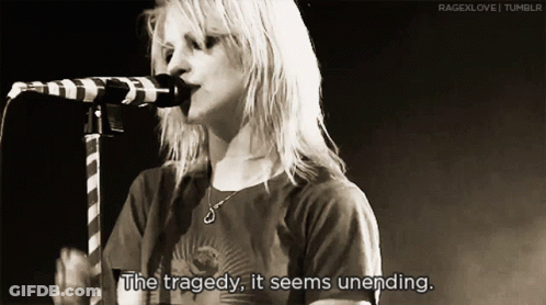 A Woman Singing Into A Microphone With The Words " The Tragedy It Seems Unending " GIF