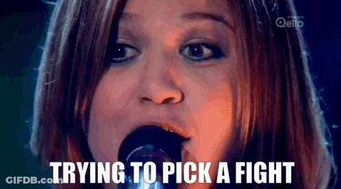 A Woman Singing Into A Microphone With The Words " Trying To Pick A Fight " Above Her GIF