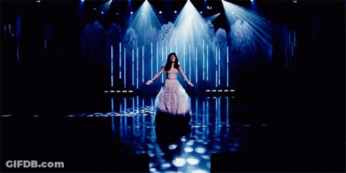 A Woman Singing On A Stage With The Words Let Her Go Can 'T Be Obsessed Anymore Below Her GIF