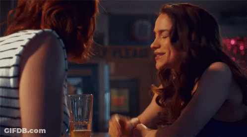 A Woman Sits At A Bar With A Sign That Says This Is What You Get When You 'Re Friends GIF