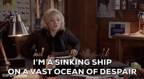 A Woman Sits At A Desk With The Words I 'M A Sinking Ship On A Vast Ocean Of Despair GIF