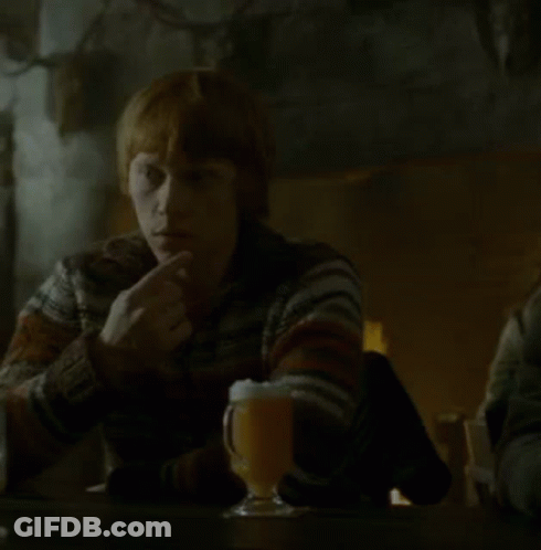 A Woman Sits At A Table With A Glass Of Beer GIF