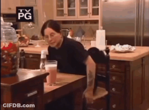 A Woman Sits At A Table With A Tv Pg Sign Above Her Head GIF