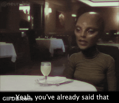 A Woman Sits At A Table With A Wine Glass And Says Yeah You 'Ve Already Said That GIF