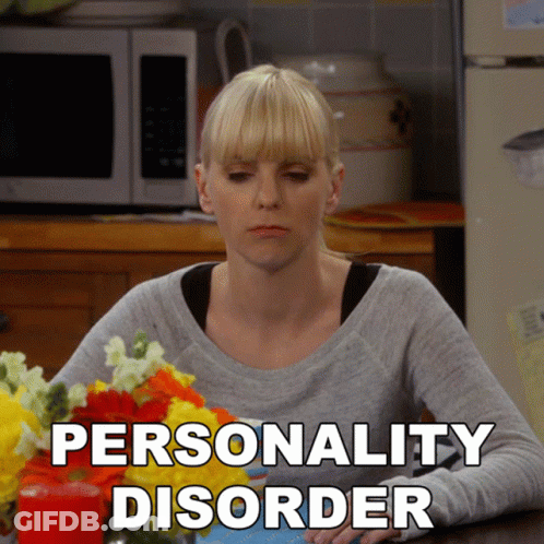 A Woman Sits At A Table With Flowers And The Words Personality Disorder Written On The Bottom GIF