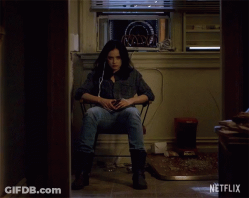 A Woman Sits In A Chair In A Room With A Netflix Logo On The Wall GIF