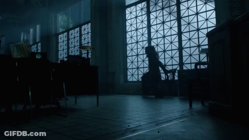 A Woman Sits In A Chair In Front Of A Large Window GIF