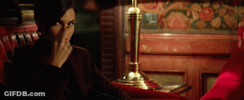 A Woman Sits In A Red Chair Covering Her Face GIF