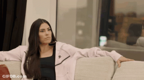 A Woman Sits On A Couch Wearing A Nike Jacket GIF
