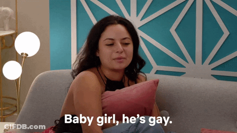 A Woman Sits On A Couch With A Pillow And Says " Baby Girl He 'S Gay " GIF