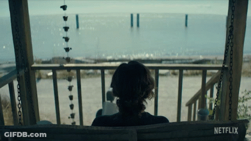A Woman Sits On A Porch Swing With A Netflix Logo Visible GIF
