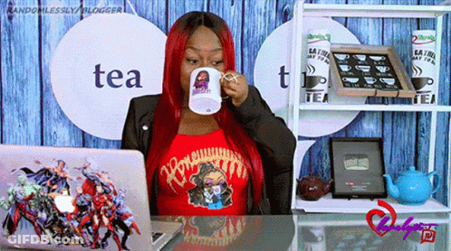 A Woman Sitting At A Desk Drinking From A Mug That Says Tea On It GIF