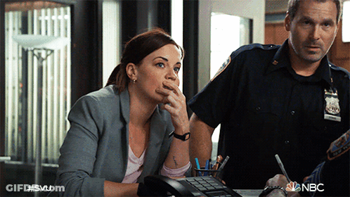 A Woman Sitting At A Desk Talking On A Phone Next To A Police Officer With #Svu Written On The Bottom GIF
