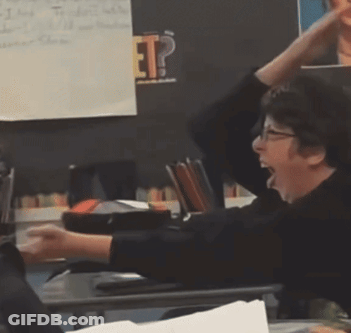 A Woman Sitting At A Desk With Her Hands In The Air In Front Of A Blackboard With The Word Ep On It GIF