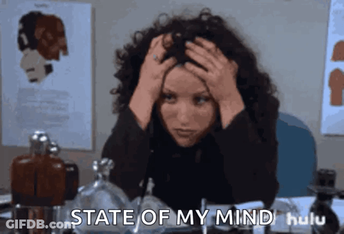 A Woman Sitting At A Desk With Her Hands On Her Head And The Words State Of My Mind GIF