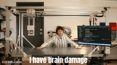 A Woman Sitting At A Desk With The Words I Have Brain Damage On The Bottom GIF
