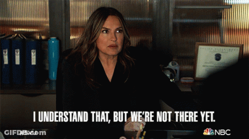 A Woman Sitting At A Desk With The Words I Understand That But We 'Re Not There Yet Written Below Her GIF