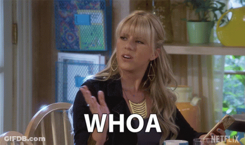 A Woman Sitting At A Table Says Whoa GIF