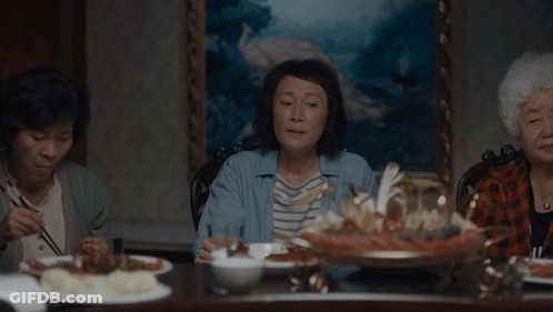 A Woman Sitting At A Table Talking About Raising Kids And Playing The Stock Market GIF