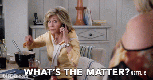 A Woman Sitting At A Table Talking On A Cell Phone With The Words What 'S The Matter Netflix Behind Her GIF
