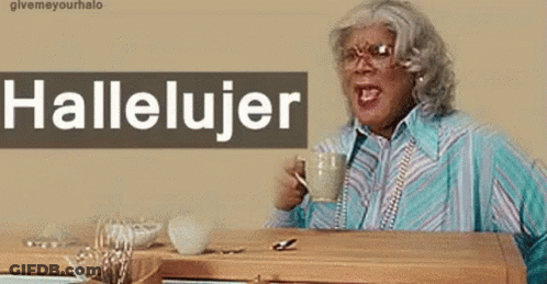 A Woman Sitting At A Table With A Cup Of Coffee And A Sign That Says Hallelujer On It GIF