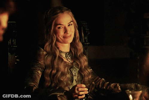 A Woman Sitting At A Table With A Glass Of Wine GIF