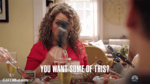 A Woman Sitting At A Table With A Glass Of Wine Says You Want Some Of This . GIF