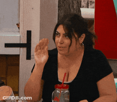 A Woman Sitting At A Table With A Mason Jar With A Red Straw GIF