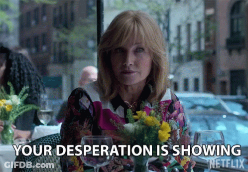 A Woman Sitting At A Table With Flowers And Wine Glasses Says " Your Desperation Is Showing " GIF