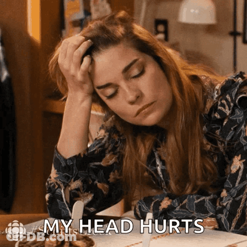 A Woman Sitting At A Table With Her Hand On Her Head And The Words My Head Hurts GIF