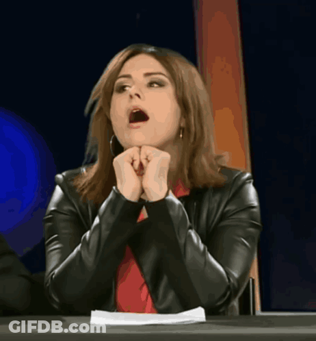 A Woman Sitting At A Table With Her Mouth Wide Open GIF