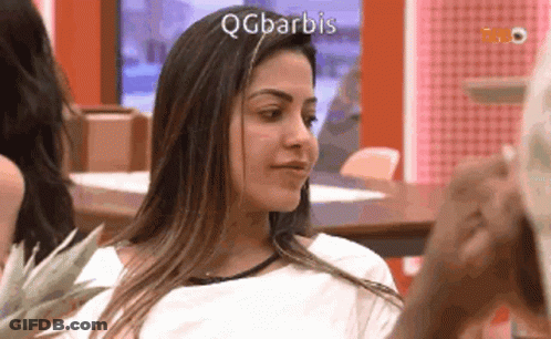 Woman Sitting At Table With QQBarbis On Face GIF