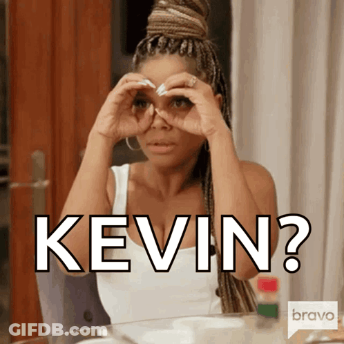 A Woman Sitting At A Table With The Word Kevin Written On Her Face GIF