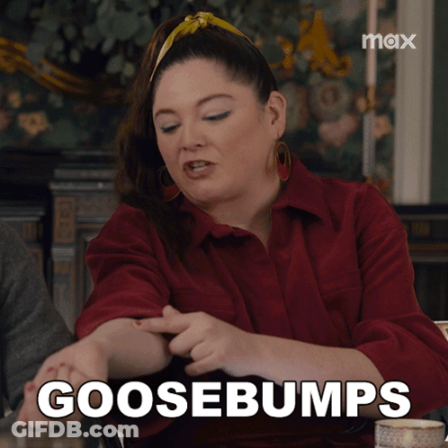 A Woman Sitting At A Table With The Words Goosebumps Written On Her Arm GIF